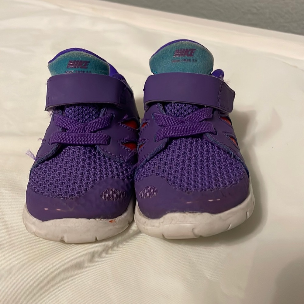 Purple Nike sneakers with some wear on the tip of the toes.